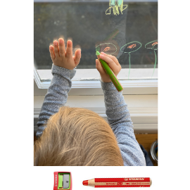 Toddler drawing flowers on window with Stabilo washable markers. 