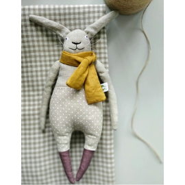 Wool, stuffed animal rabbit, with long pointy ears, a yellow scarf, polka dot pants, and purple feet..