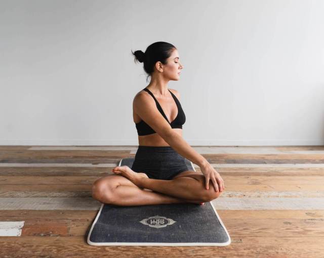 woman sitting on a yoga mat doing a yoga pose