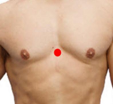man's torso with a red dot in the middle of his chest representing acupressure point