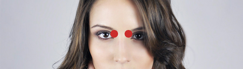 woman face with two red dots between her eyes representing acupressure points