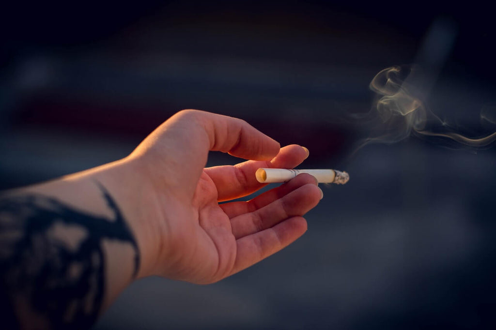 close up photography of a person holding cigarette