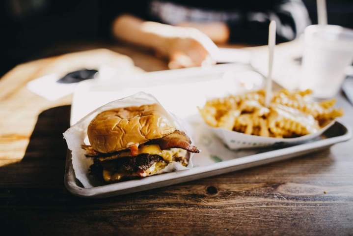 plate containing fries and bacon burger