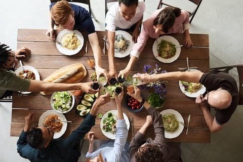 friends toasting wine over a variety of food