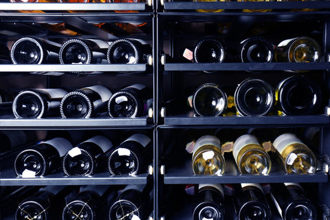 wine bottles stored on their side in a temperature-controlled wine cabinet