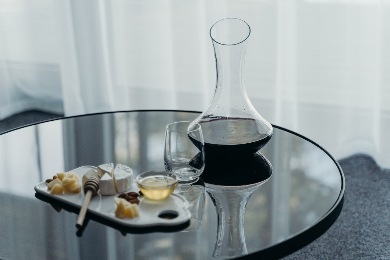 Wine decanter and glass with small cheese platter