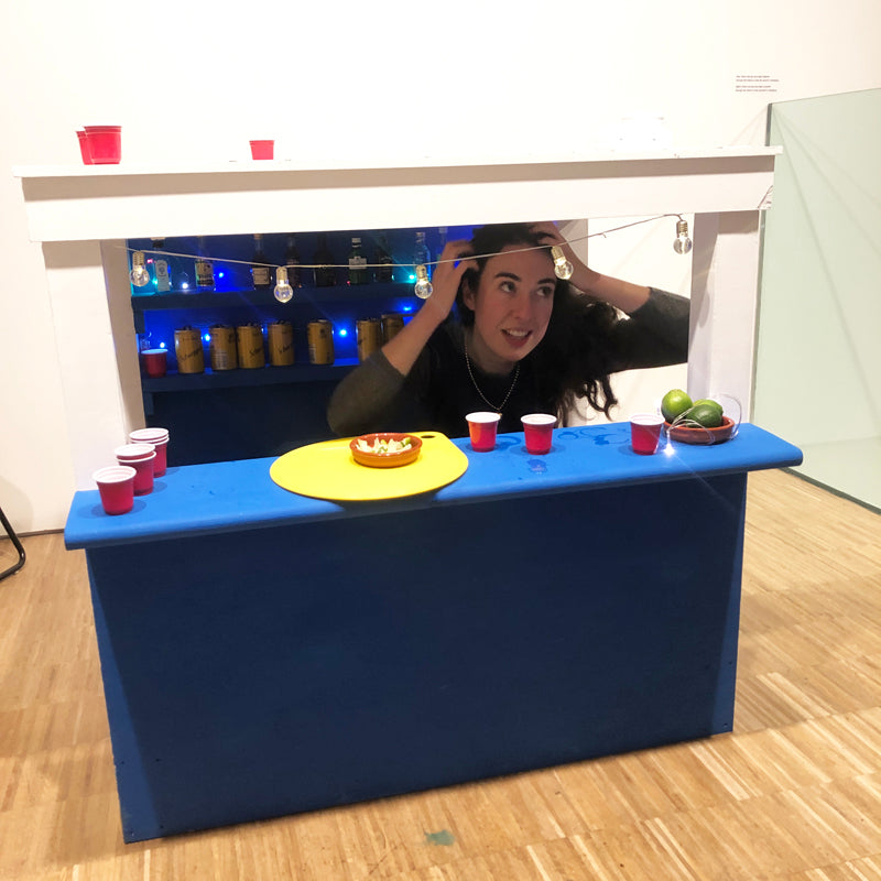 A miniature bar in blue and yellow with tiny cups of alcohol