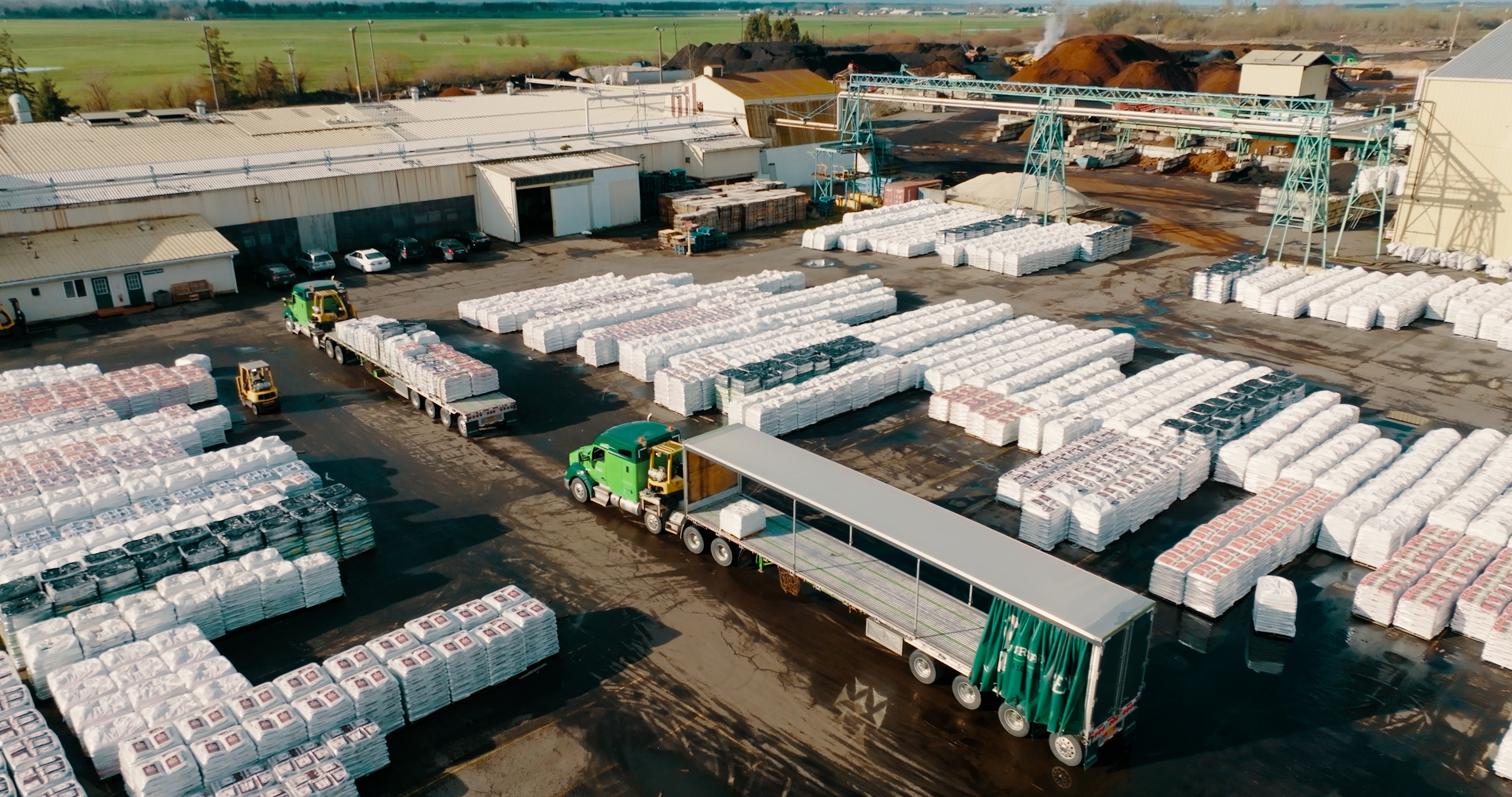 Aerial photo of semi trucks being loaded with bagged soil products