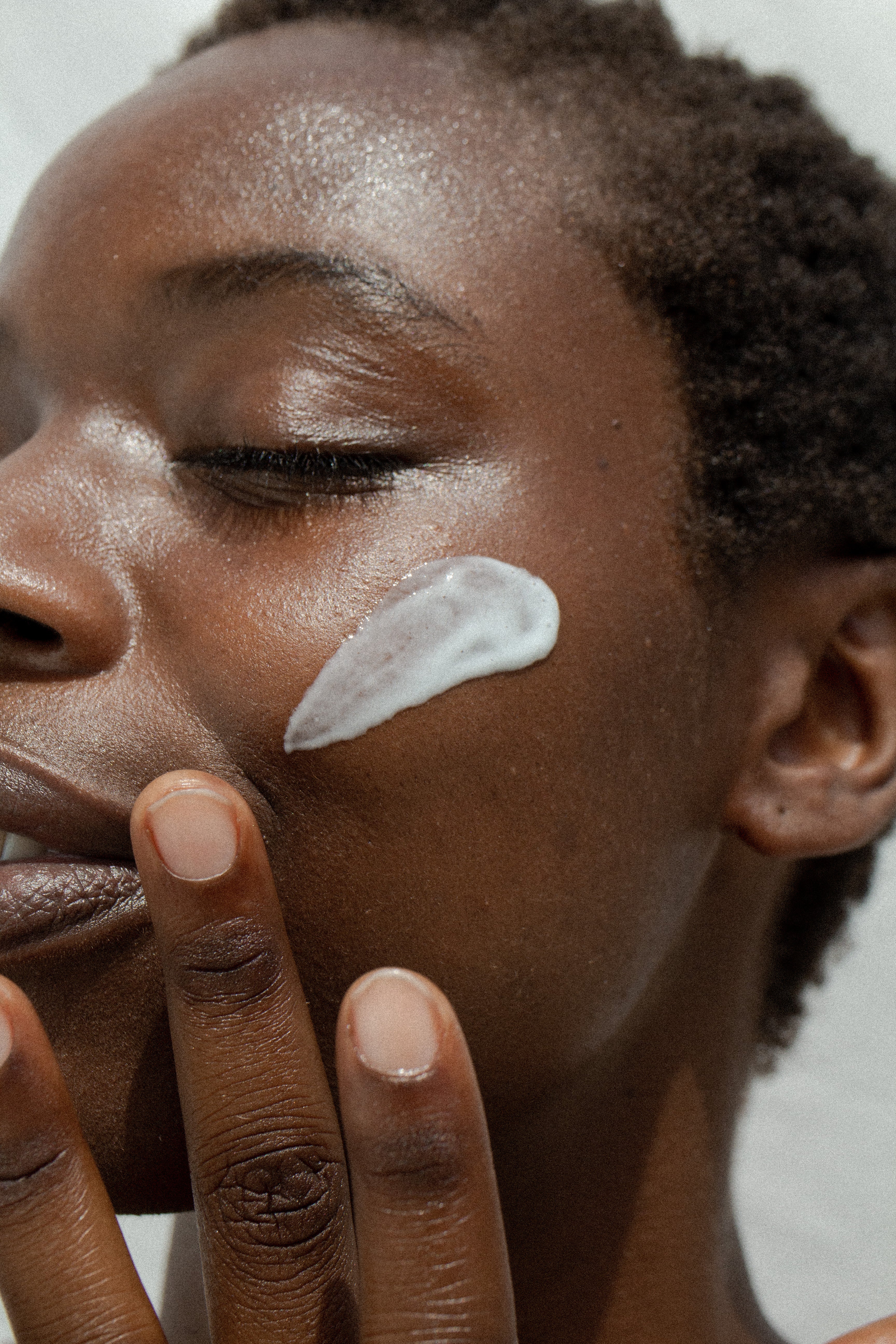 A young woman applying face cream