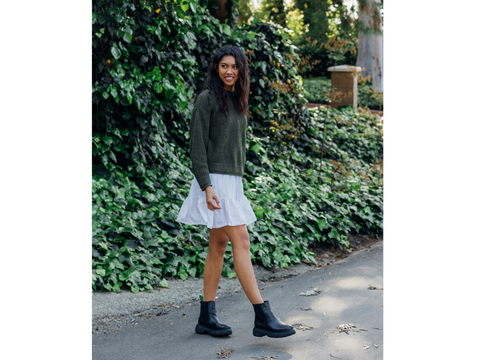 Woman in sweater and skirt wearing black boots (LUNA BOOTS)