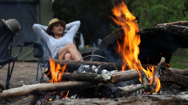 Woman laying back near the campfire