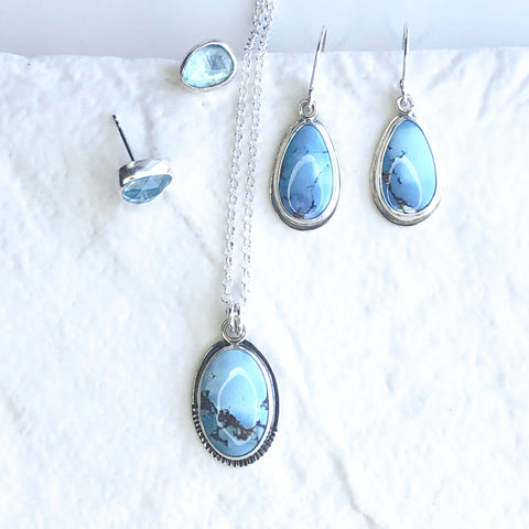 Lavender turquoise pendant and drop earrings and a pair of blue topaz stud earrings.