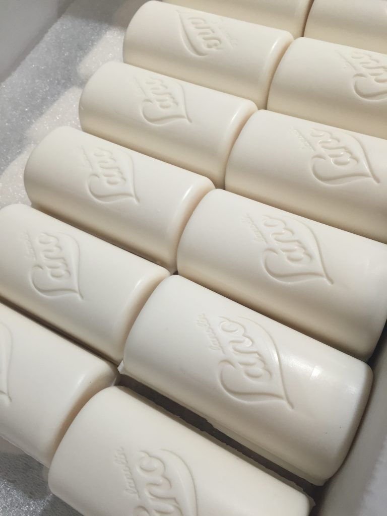 Lanolin egg white and goats milk cleansing bars lined up in production line 