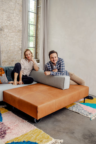 Berberlin Rugs founders Julia and Walid reclining on freistil Rolf Benz couch in their Berlin office.