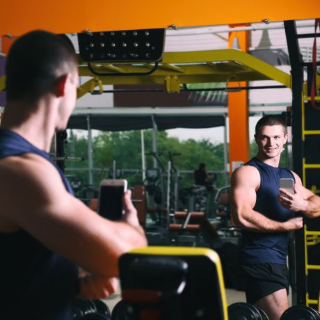 man taking a biceps picture at the gym