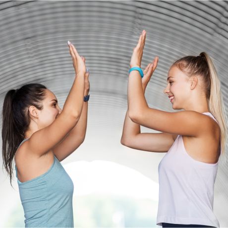 two women excited about fitness high fiving