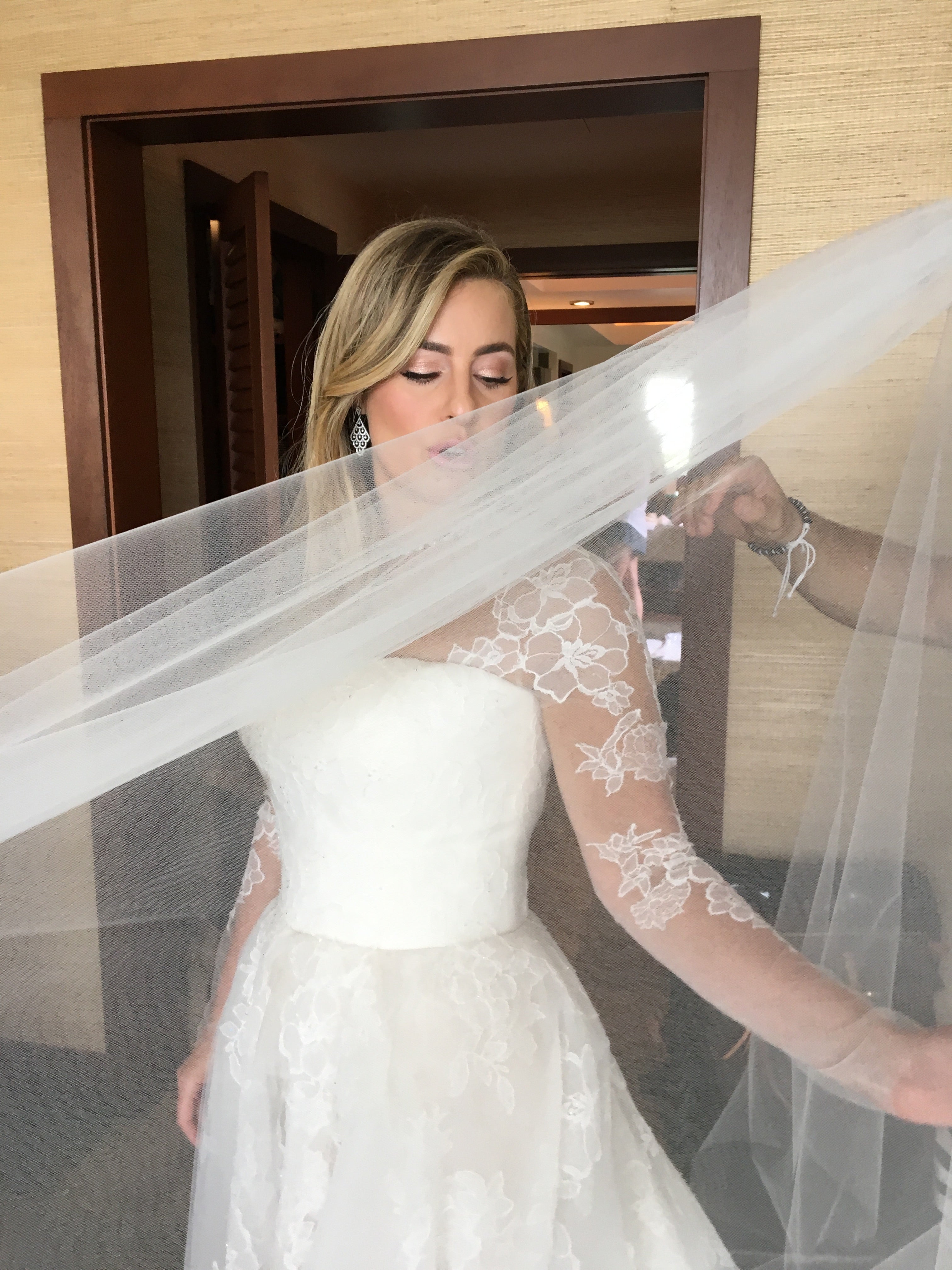 Bride looks down to show off her soft and delicate bridal makeup. Bride wears a Rose gold eyeshadow called Dreams, false lashes and Heather lipgloss. Makeup by Valerie