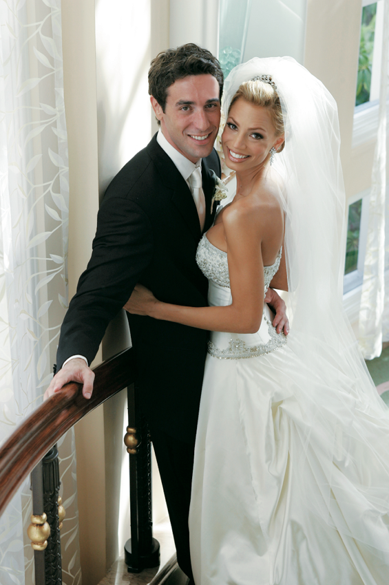 Bride and Groom smile big on a staircase after their ceremony.