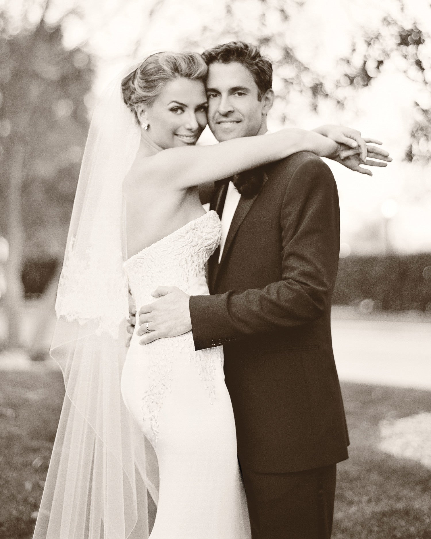 A black and white image of a Bride and Groom hugging softly outside of their wedding venue 