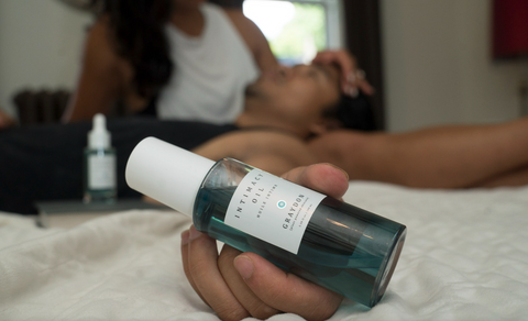 Couple with bottle of Graydon Skincare Intimacy Oil in forefront