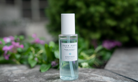 Bottle of Face Food Mineral Mist in front of greenery