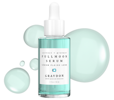 Bottle of Graydon Skincare Fullmoon Serum with blue product drops in background.