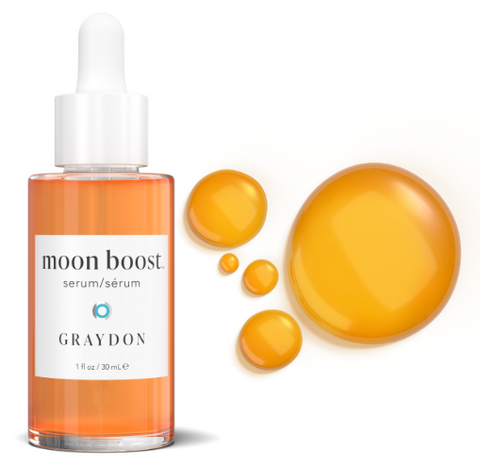 Bottle of beautiful orange Graydon Skincare Moon Boost Serum next two product drops.
