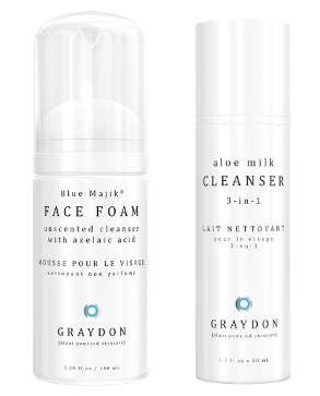 A foaming cleanser in a white bottle next to a soothing creamy cleanser in a white bottle against a white background