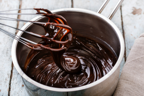 Pot of melted chocolate with whisk