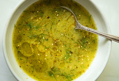 Garlicky Za’atar Dressing in a white bowl with a silver spoon