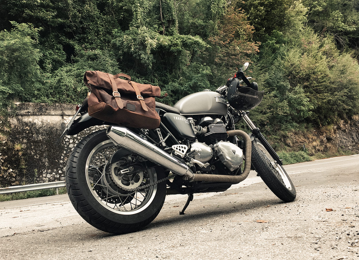 Moto Thruxton 900 avec grande sacoche marron souple.