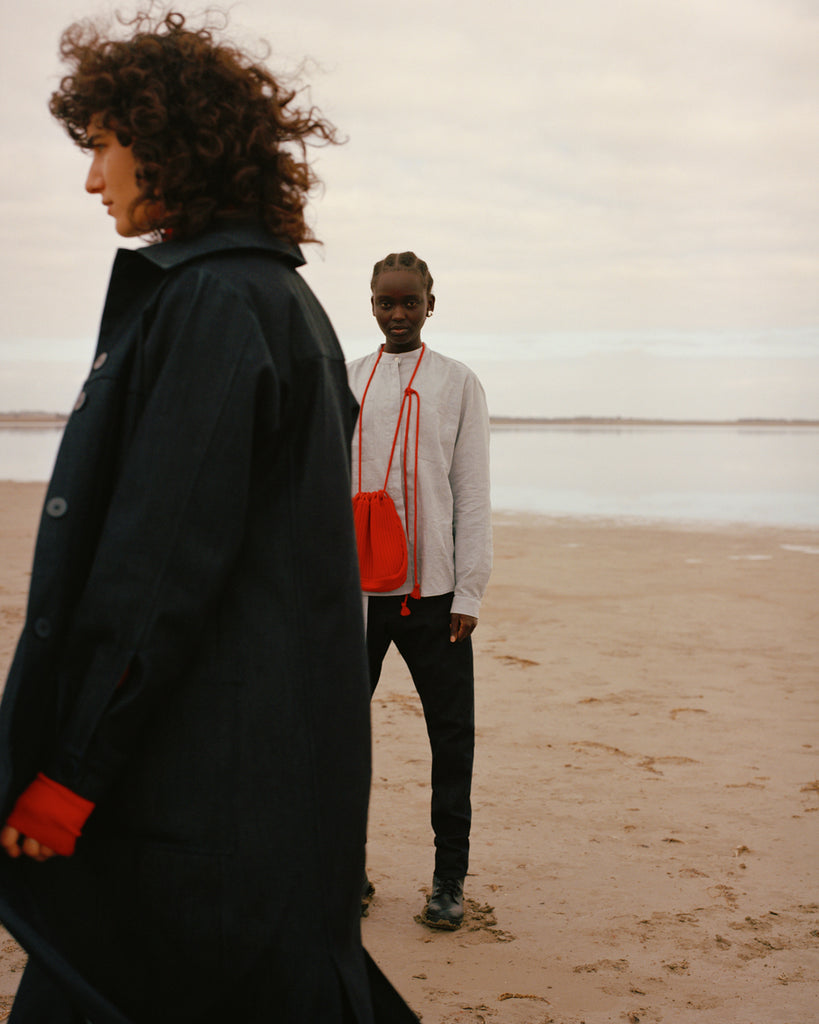 A.BCH Birth Campaign image with two woman, one with a red bag and the other walking past with red sleeve detail.