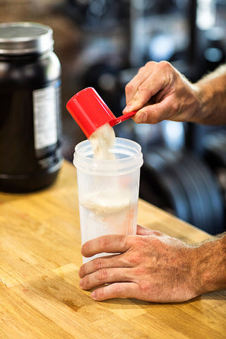 Man mixing creatine in shaker bottle