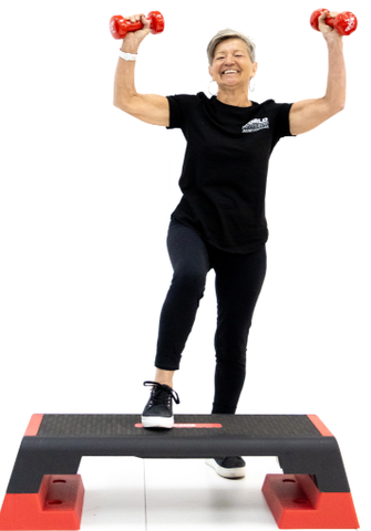 Lifestyle image of woman with aerobic step and dumbbells