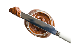 Scoop of Nutella on a knife resting on top of Nutella jar