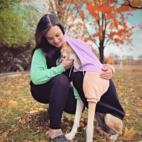 a lady wearing a matching hoodie as her pit bull