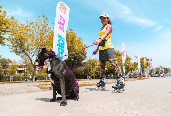 A woman rollerblading with her dog