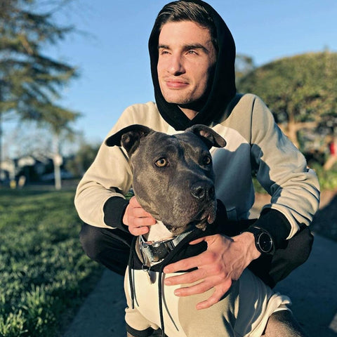 a happy pitbull with his owner in matching hoodies