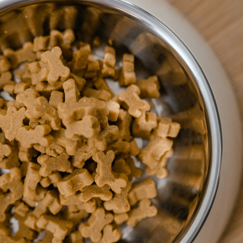 A big bowl of dog biscuits shaped like bones.