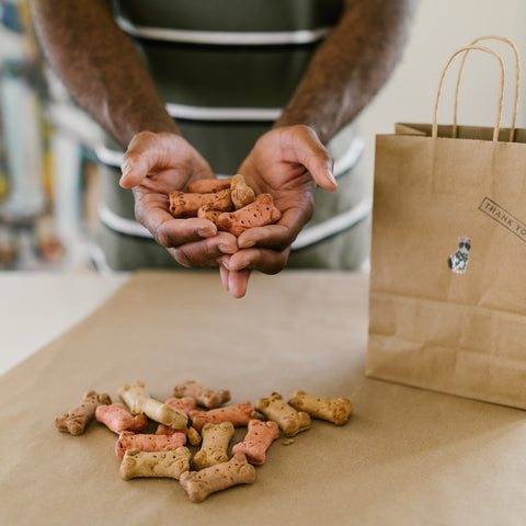 a man holding a handful of dog food