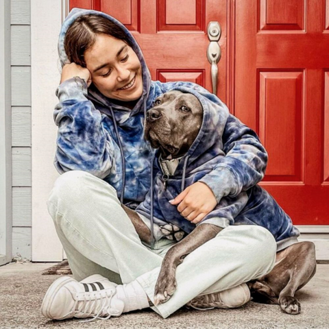 a pitbull and its owner wearing matching hoodies