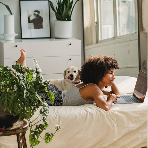 a puppy and a lady lying on the bed