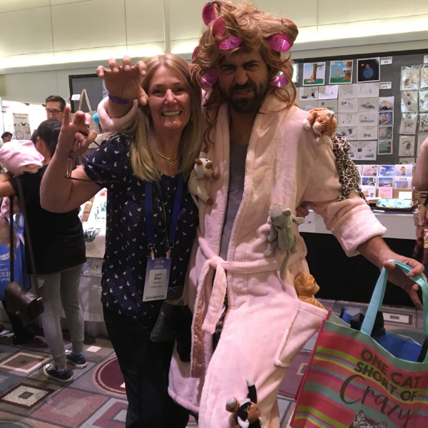 a man dressed up as a crazy cat lady with curlers in his hair and stuffed cats pinned to his robe