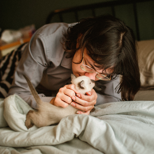 a girl kissing her white cat