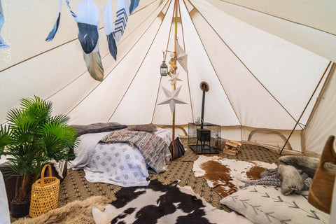 Glawning interior showing stove and chimney near the side of the tent surrounded by protective cage