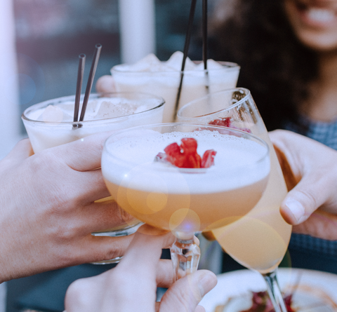Group cheering each other with cocktails - Food and Drink Sales - how to make money for your fundraiser through a trivia event
