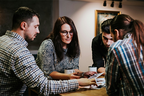 People working at a table together looking through files