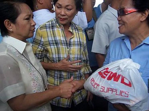 Arroyo in a barong while distributing relief goods during Typhoon Frank