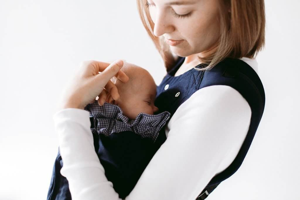 Mother holding newborn in Weego ORIGINAL baby carrier