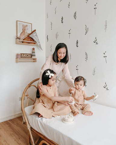 Mother with her two children sitting on a bed